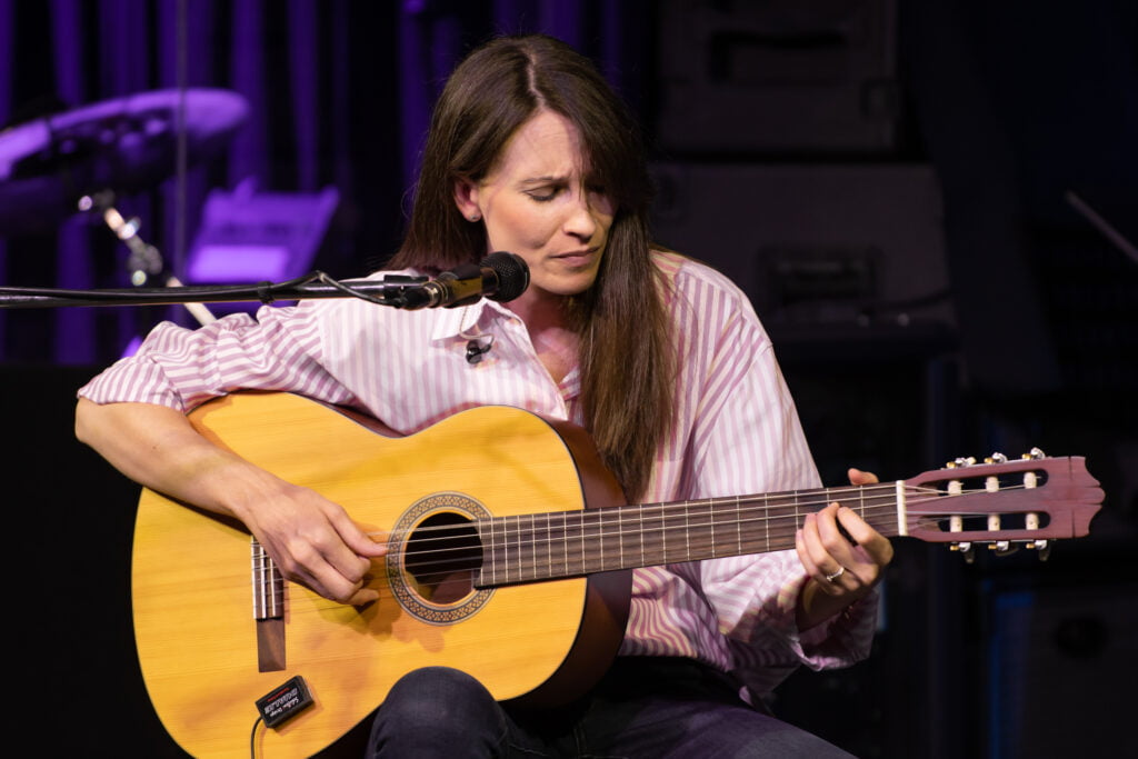 Alyce Chulu playing acoustic guitar