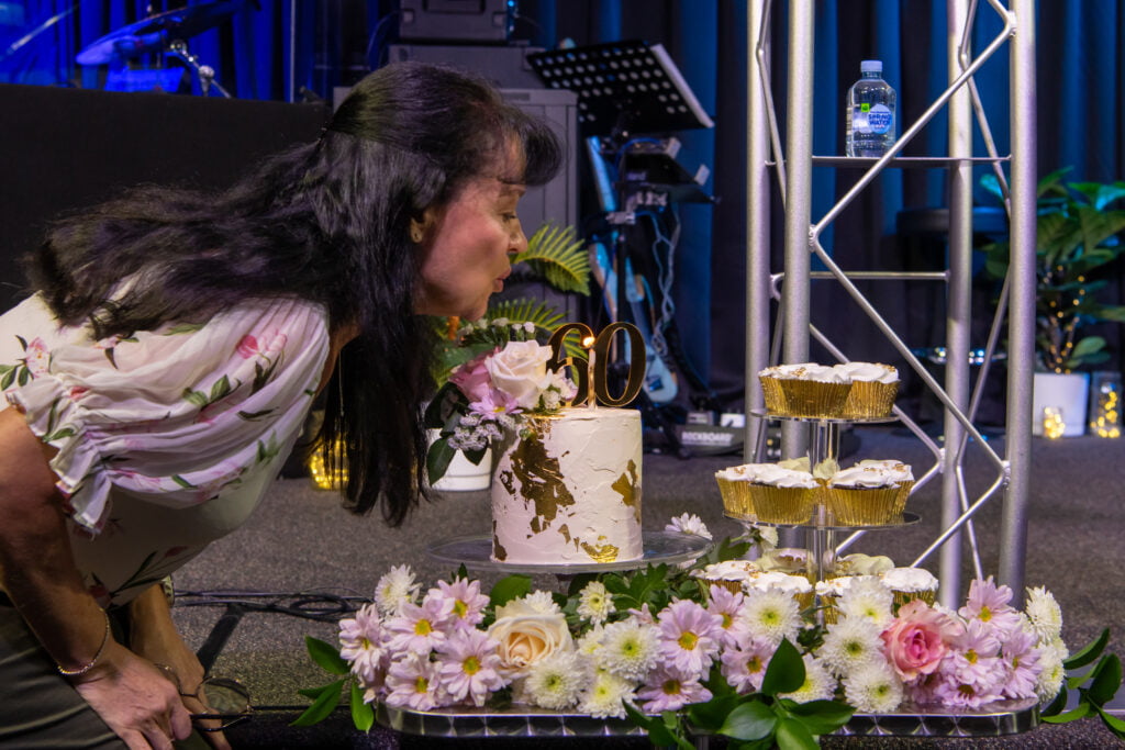 Ps Pamela blowing out candle on a birthday cake